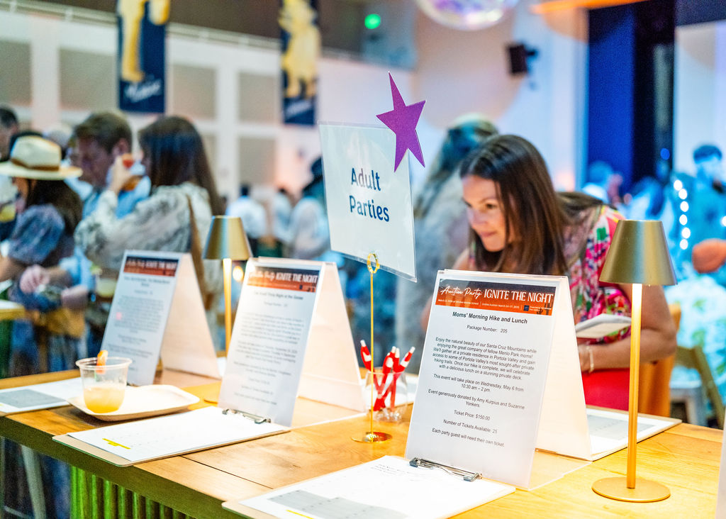 Guest browsing silent auction bid sheets